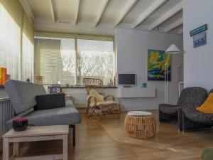 a living room with a couch and chairs and a table at Family bungalow with garden in Sint Maartenszee