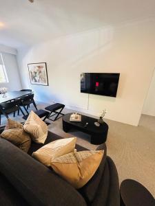 悉尼KozyGuru Camperdown Cozy 2-Bed Apt and Parking的带沙发和桌子的客厅