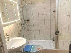 a bathroom with a shower and a toilet and a sink at Inviting bungalow with private garden in Sint Maartenszee +21 photos