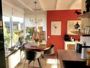 a kitchen with a wooden table and a red wall at Inviting bungalow with private garden in Sint Maartenszee