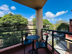 悉尼KozyGuru Camperdown Cozy 2-Bed Apt and Parking的带桌椅的阳台，可欣赏美景