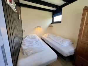 two beds in a small room with white sheets at Bungalow for 4 people in Wildrijk in Sint Maartenszee