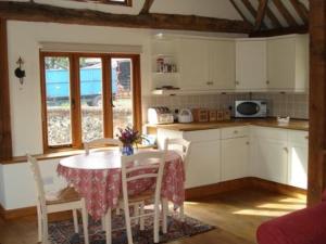 a kitchen with a table and chairs and a kitchen with a table and a kitchen at Bullrush at White Pond Farm in Henley on Thames +2 photos