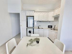 a white kitchen with a white table and chairs at Gaviota in Puerto de la Cruz
