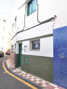 a white building with a green door on a street at Gaviota in Puerto de la Cruz +20 photos