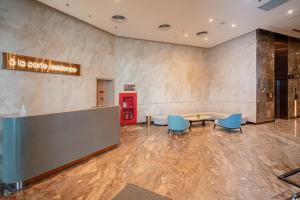 a lobby with a waiting area with blue chairs and a table at Seaside Elegance- À la carte Hotel Hạ Long in Ha Long +47 photos