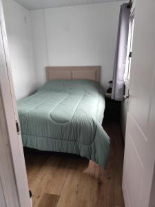 a small bedroom with a green bed in a room at Altos del parque in Minas