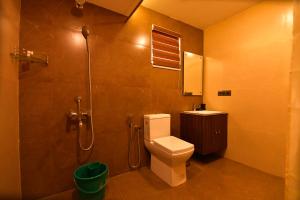 un baño con inodoro y ducha en Garuda Luxury Bungalow, en Trichūr