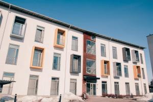 a white building with windows on a street at Cozy Penthouse Loft - Near the Airport in Vantaa
