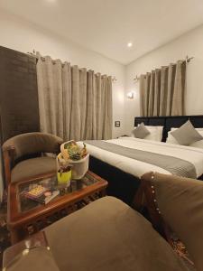 a hotel room with two beds and a table at Gulmarg Orchard in Gulmarg