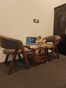a table and two chairs with a laptop on it at Gulmarg Orchard in Gulmarg