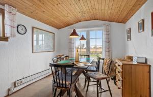 a dining room with a table and chairs and a clock at Cozy Home In Bogense With Wifi in Bogense