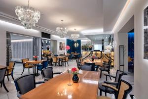 restauracja ze stołami, krzesłami i żyrandolami w obiekcie Hotel Maria w mieście Dębno Polskie
