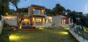 a house with lights in the yard at night at Topos Villas in Parga