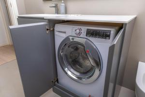 a washing machine under a counter in a bathroom at Kramer House-Porta Venezia-5min to Duomo in Milan