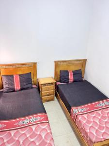 Dos camas una al lado de la otra en una habitación. en Appartement Grande Stade Tanger, en Tánger
