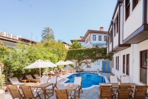 a patio with tables and chairs and a swimming pool at Aspen Hotel Kaleiçi in Antalya