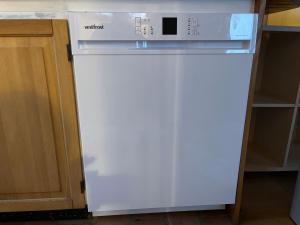 a white refrigerator with a microwave on top of it at Hyggelig hytte - perfekt til par in Hundested