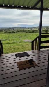 a wooden deck with a view of a field at Altos del parque in Minas +10 photos