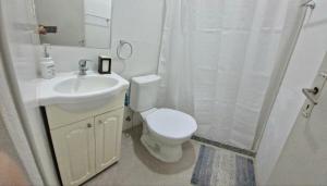 a bathroom with a toilet and a sink and a shower at Luminoso y Acogedor Espacio in Paysandú