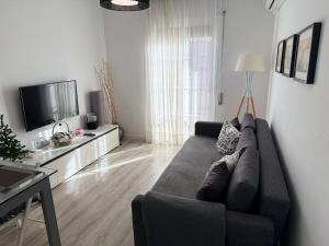 a living room with a couch and a television at Apartamento Vega in Baena