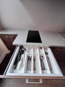 a kitchen counter with silver utensils in a drawer at Cozy Studio in North London in London