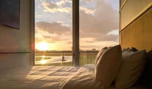 a bedroom with a bed and a large window at Showcase Hotel Kota Kinabalu in Kota Kinabalu