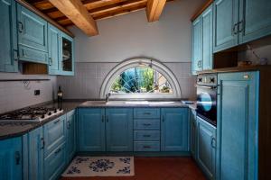 a kitchen with blue cabinets and an arched window at La Pasqualina B&B in Faenza