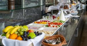a buffet line with several trays of fruits and vegetables at PLAZA INN Stuttgart-Ditzingen in Ditzingen