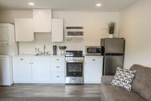 a kitchen with white cabinets and a couch at River City Inn in Parsons