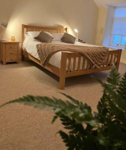 a bedroom with a wooden bed with two pillows at Courtyard Cottage with hot tub and walled garden in Hubberston