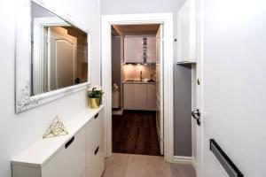 - un couloir avec un miroir et un lavabo dans l'établissement Greenkey Studio H17, à Reykjavik