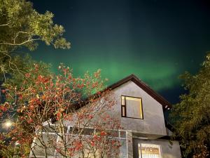 une image de l'aurore boralis derrière une maison dans l'établissement Greenkey Studio H17, à Reykjavik