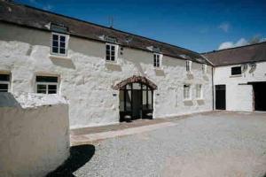 a large white building with a large parking lot at Courtyard Cottage with hot tub and walled garden in Hubberston +23 photos