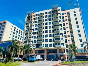 un grande edificio bianco con palme di fronte di Royal Crown Scsp KK CBD near Imago a Kota Kinabalu