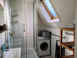 a bathroom with a shower and a washing machine at Cozy holiday home in Sint Maartenszee in Sint Maartenszee +26 photos