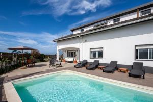 a swimming pool in front of a house at Silvercoast Apartments - swimming pool & jacuzzi in Atouguia da Baleia