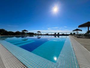 a large swimming pool with a view of the ocean at Quinta Saleiro Guesthouse in Olhão