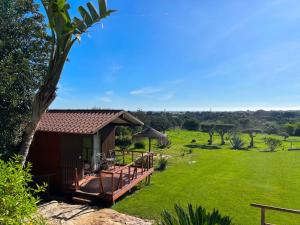 a house with a deck and a grass field at Quinta Saleiro Guesthouse in Olhão