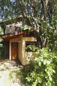 a small house with a tree in front of it at Hermosa Casa cerca del Teleférico Cerro Otto in San Carlos de Bariloche