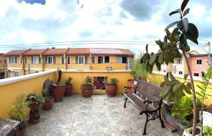 a balcony with a bench and a bunch of potted plants at Travelers Hub 1 Camella Tarlac in Tarlac