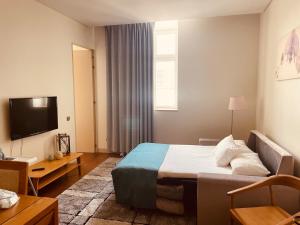 a hotel room with a bed and a television at The João I Collection Two Bedroom in Lisbon