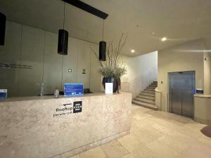 a lobby with a counter with a vase of flowers at The João I Collection Two Bedroom in Lisbon +15 photos