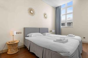 a bedroom with a large bed and a window at The João I Collection Two Bedroom in Lisbon