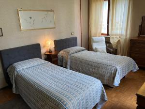 a hotel room with two beds and a lamp at CASA PANORAMICA in Loranzè