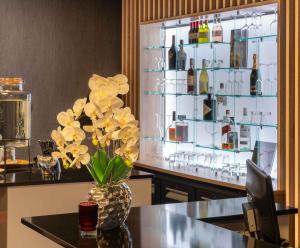 a vase with flowers on a table in a bar at PLAZA Premium Den Haag City Center in The Hague +70 photos