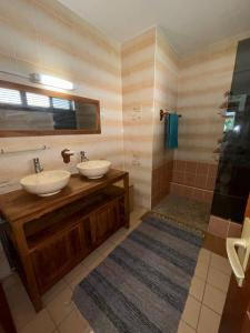 ein Badezimmer mit zwei Waschbecken und einer Dusche in der Unterkunft L’Amandine in Sainte-Anne + 11 Fotos