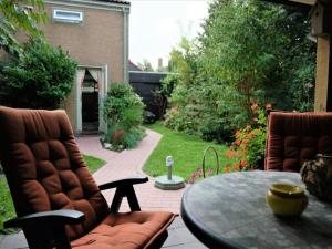 a patio with two chairs and a table on a patio at Holiday home in Petten near beach in Petten
