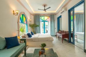 a bedroom with a bed and a couch and a piano at Bhagvatam by the Ganges in Shivpuri