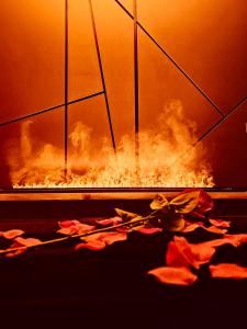 un foyer extérieur avec de la fumée et des fleurs au sol dans l'établissement Cocon détente pour 2 avec hammam et jacuzzi privé Mer Lac, au Barcarès